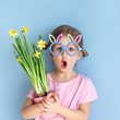 Little girl with easter glasses and flowers