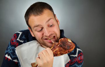 Man eating turkey leg for thanksgiving